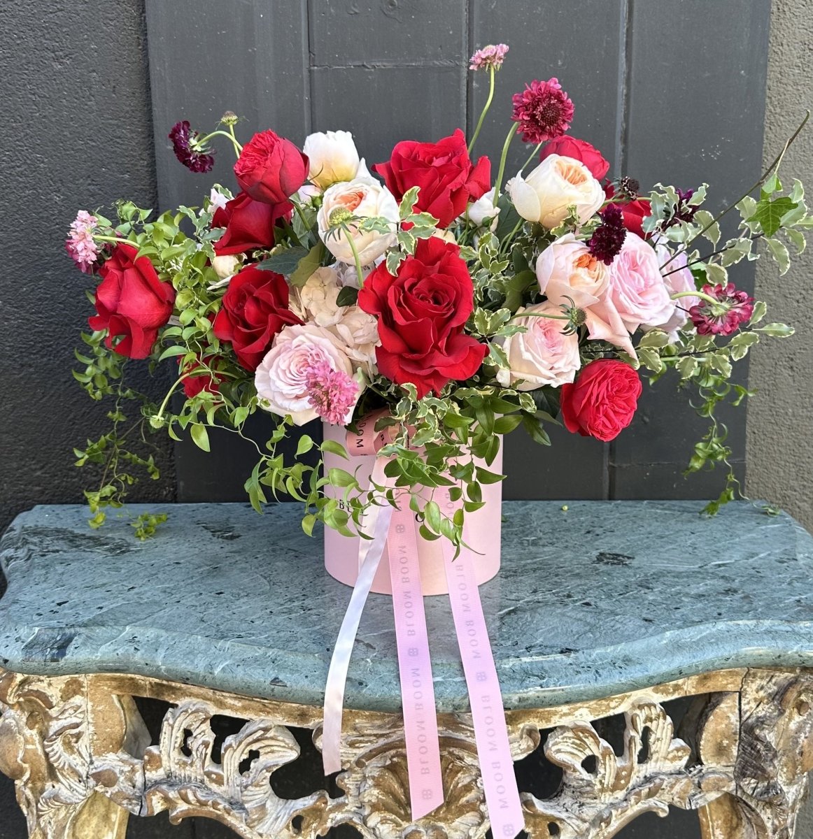 Strawberry Champaign Box - luxury hatbox flower arrangement with red roses, pink garden roses, and trailing greenery