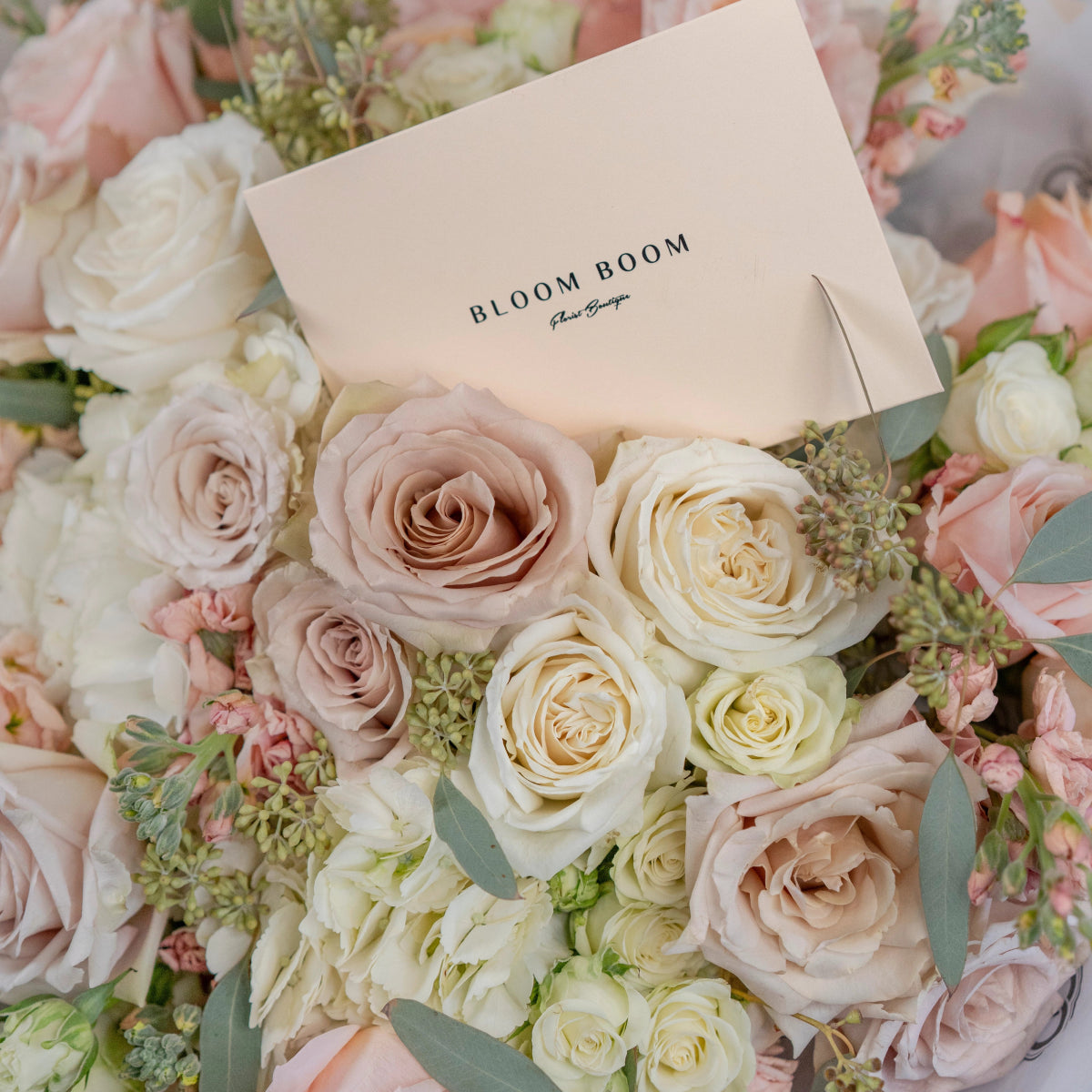 Bloom Boom luxury flower bouquet with blush pink and cream roses, white hydrangeas, and eucalyptus in soft pastel tones