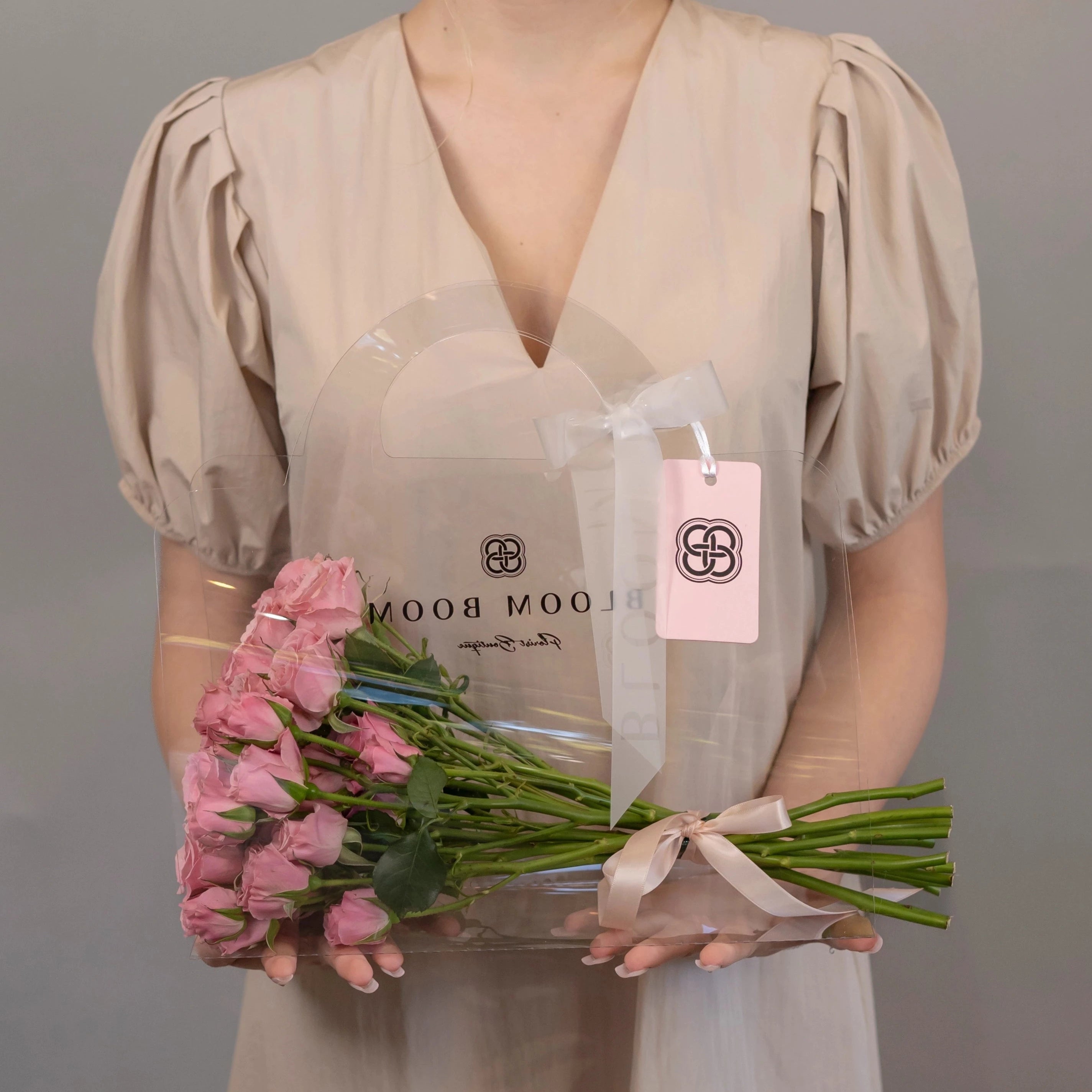 Bloom Boom clear acrylic flower box with pink roses bouquet, branded packaging with pink gift tag