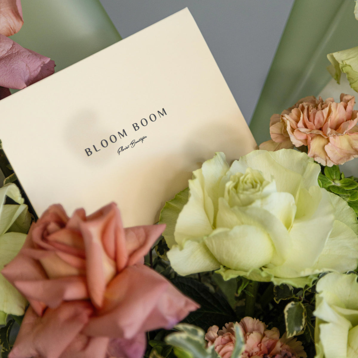 Bloom Boom flower bouquet with cream card featuring white roses, pink carnations and green hydrangea