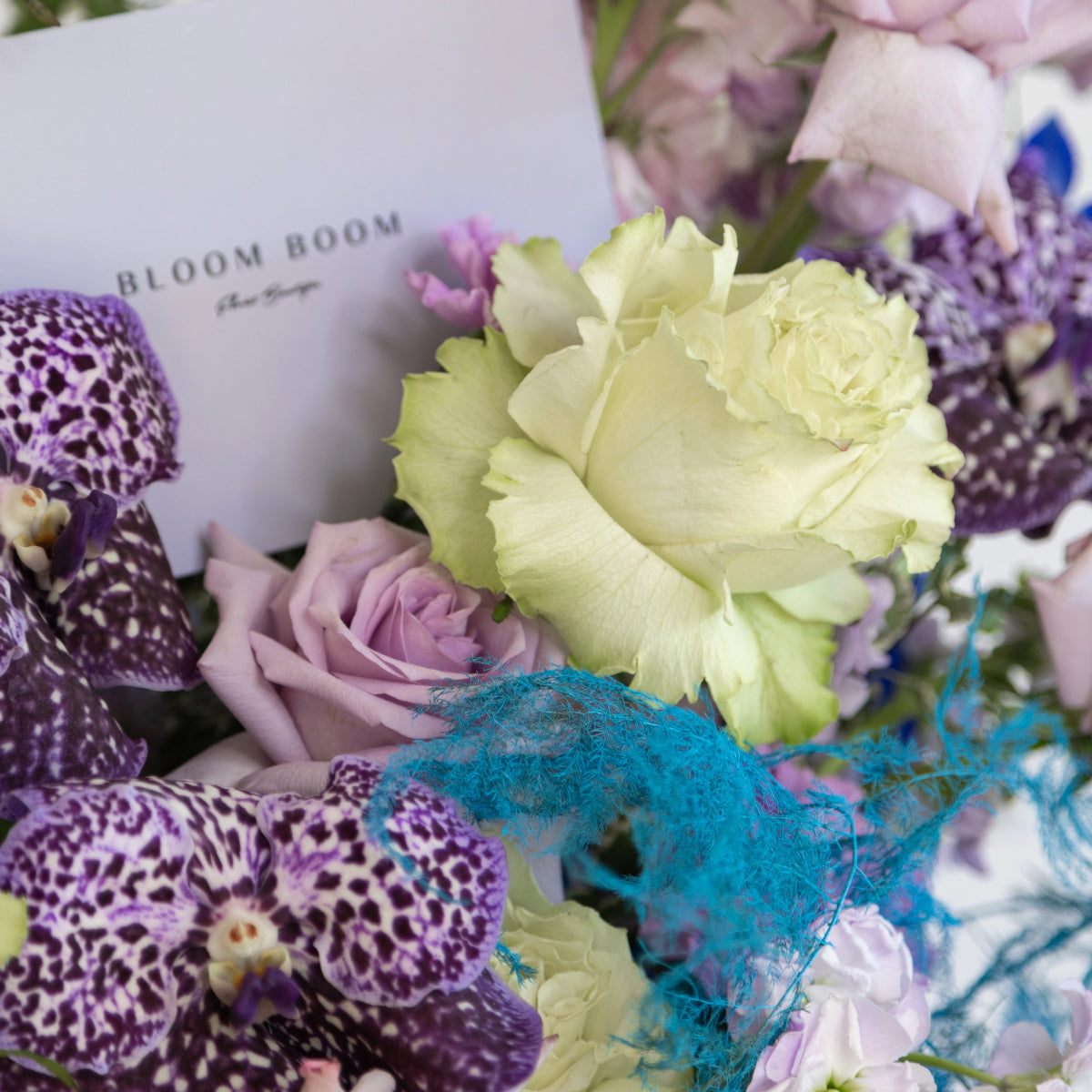 Bloom Boom luxury flower bouquet with purple spotted orchids, pale green roses, turquoise accents and white gift box