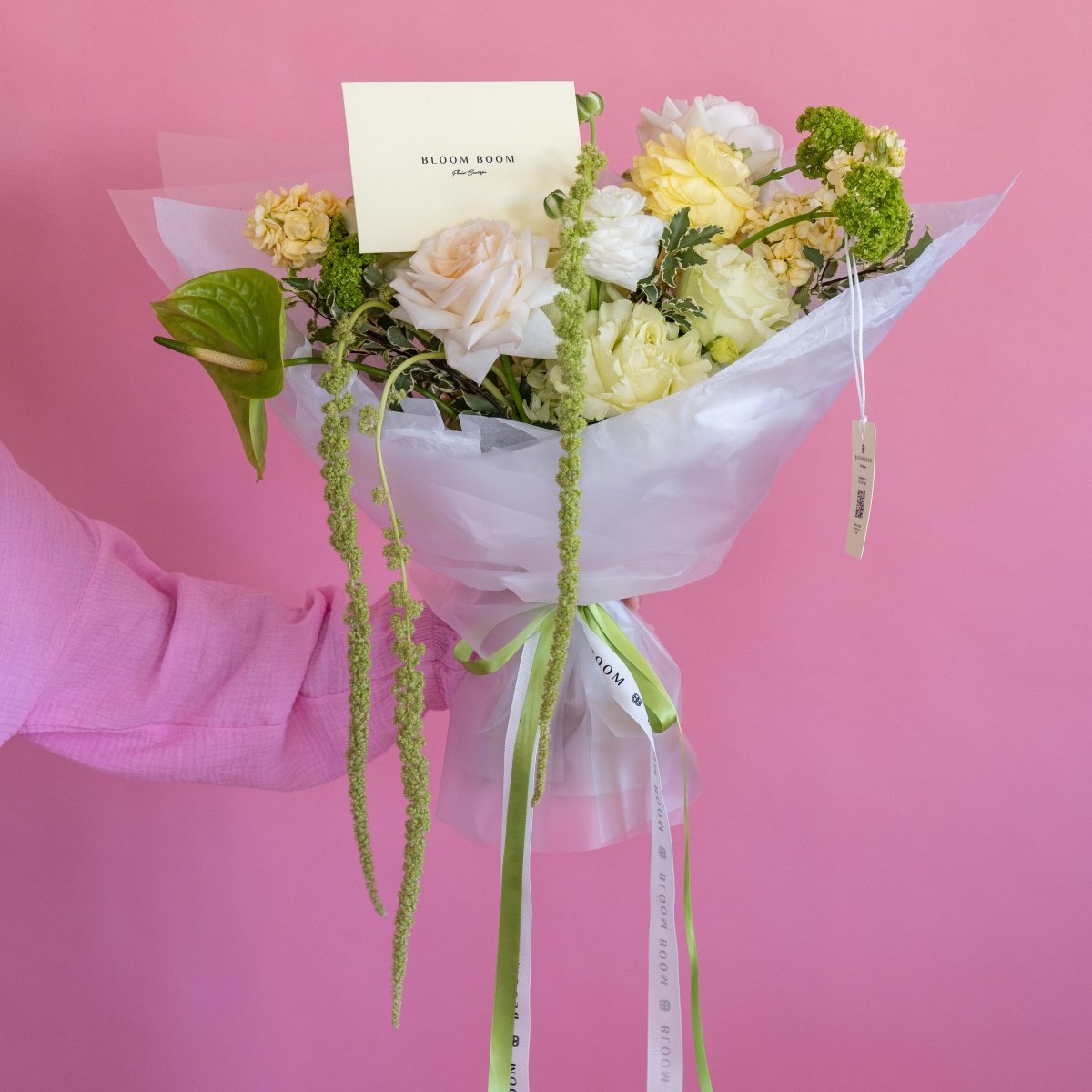 Soft touch bouquet with white and peach roses, green amaranthus, wrapped in clear cellophane with Bloom Boom card