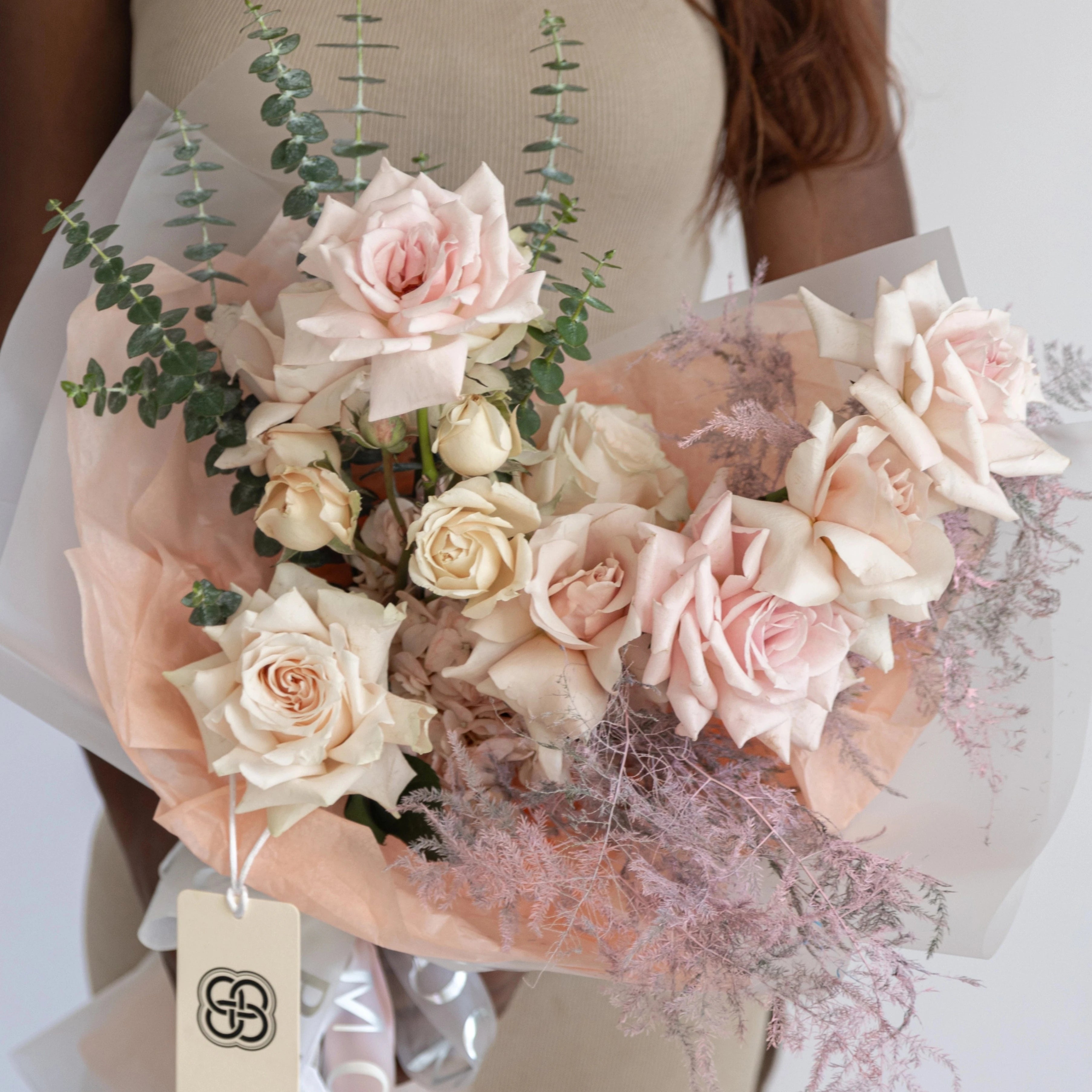 Blush pink and cream rose bouquet with eucalyptus greenery and smoky bush wrapped in pink paper - Los Angeles florist