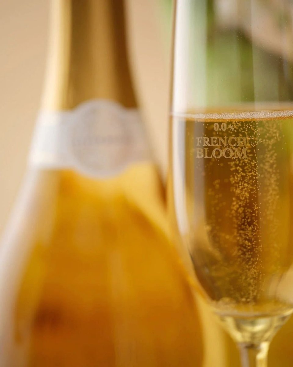 Two champagne flutes filled with golden sparkling French Bloom 0.0% alcohol-free bubbly with elegant bubbles