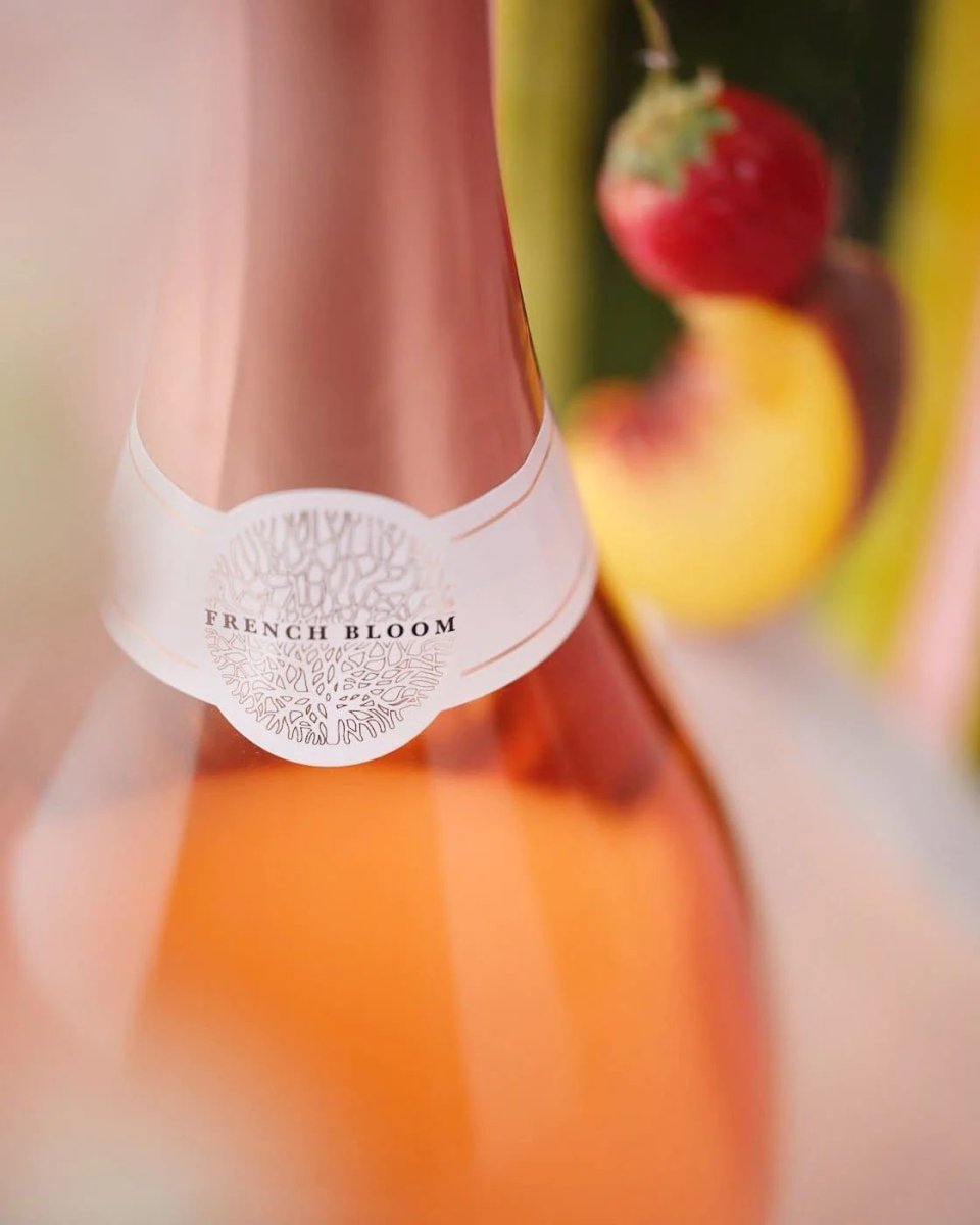French Bloom rosé sparkling wine bottle with white decorative label featuring ornate botanical design