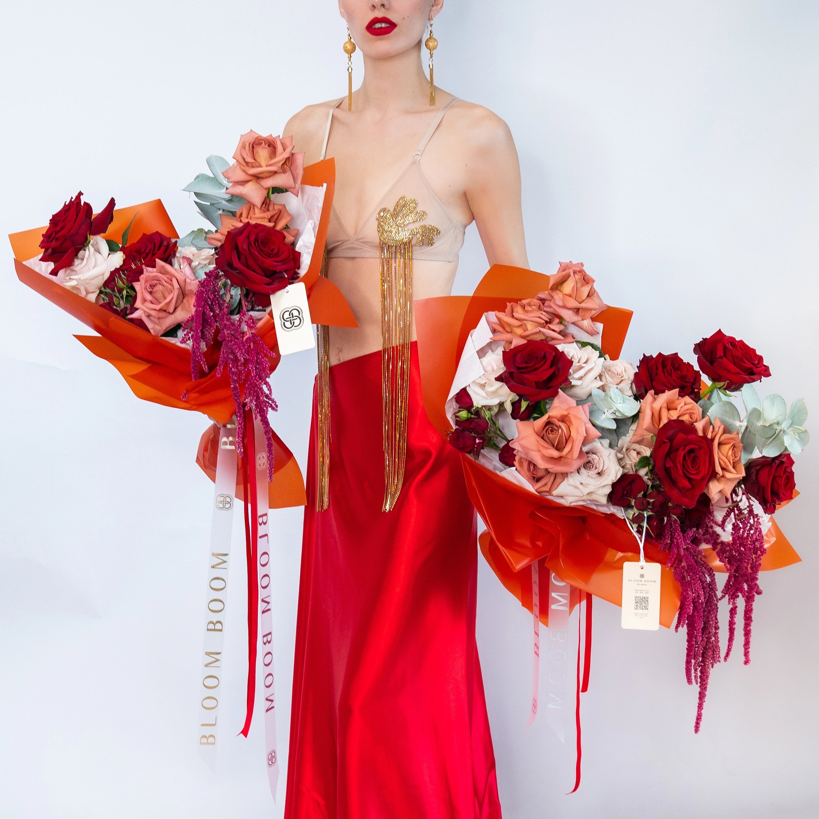 Luxury mixed rose bouquets in orange paper wrapping with red and pink roses, purple amaranth, and eucalyptus leaves