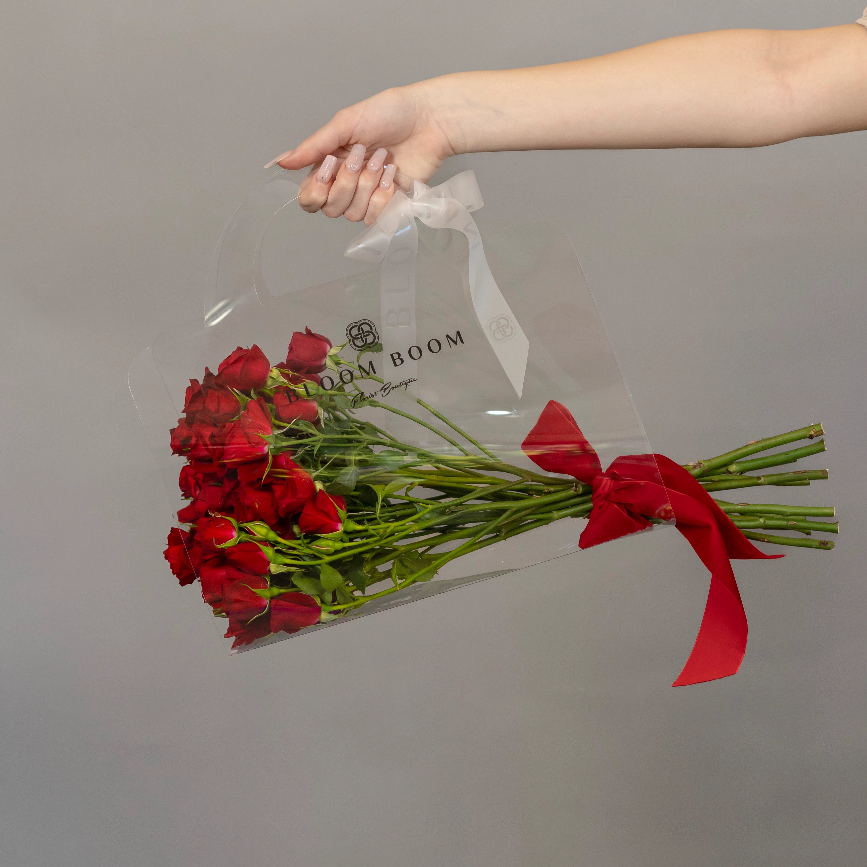 Red spray roses bouquet in clear gift bag with red ribbon bow from Bloom Boom Flowers Los Angeles florist