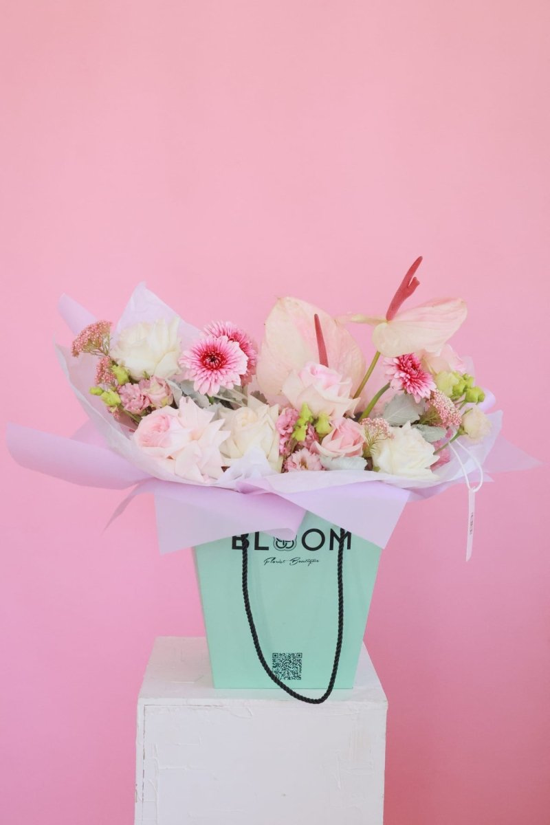 Small mixed flower bouquet with white anthurium, pink roses and gerberas in mint green Bloom gift bag