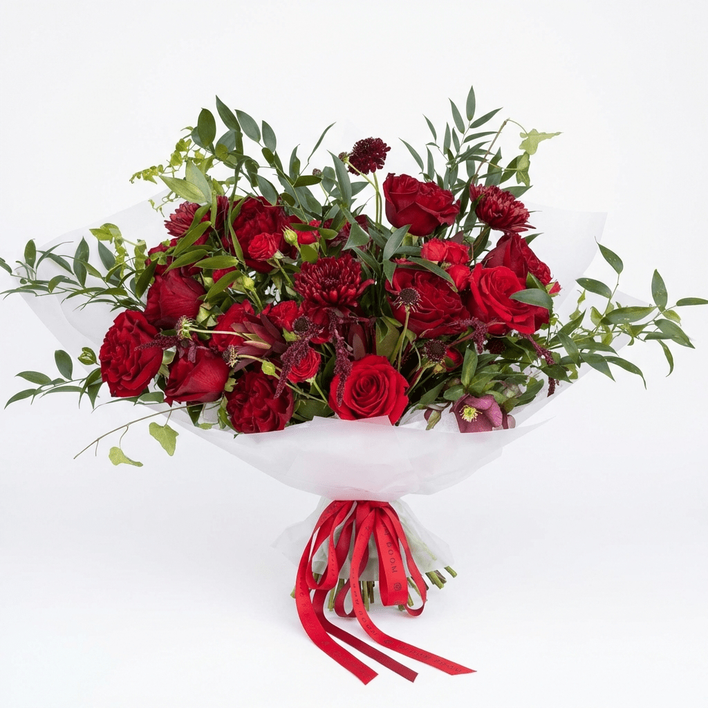 Bordeaux luxury flower arrangement - deep red garden roses with burgundy chrysanthemums wrapped in translucent white paper with a red ribbon