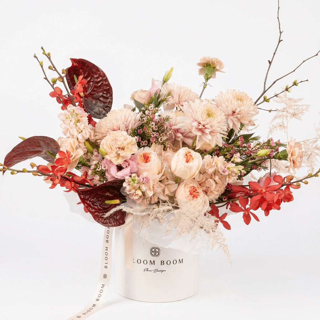 The Love Note flower arrangement - peach garden roses, dahlias, burgundy anthuriums, red orchids in Bloom Boom hat box