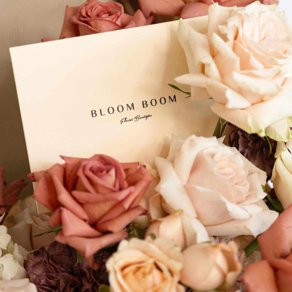 Bloom Boom flower boutique arrangement with blush pink and cream roses in neutral tones with branded white card