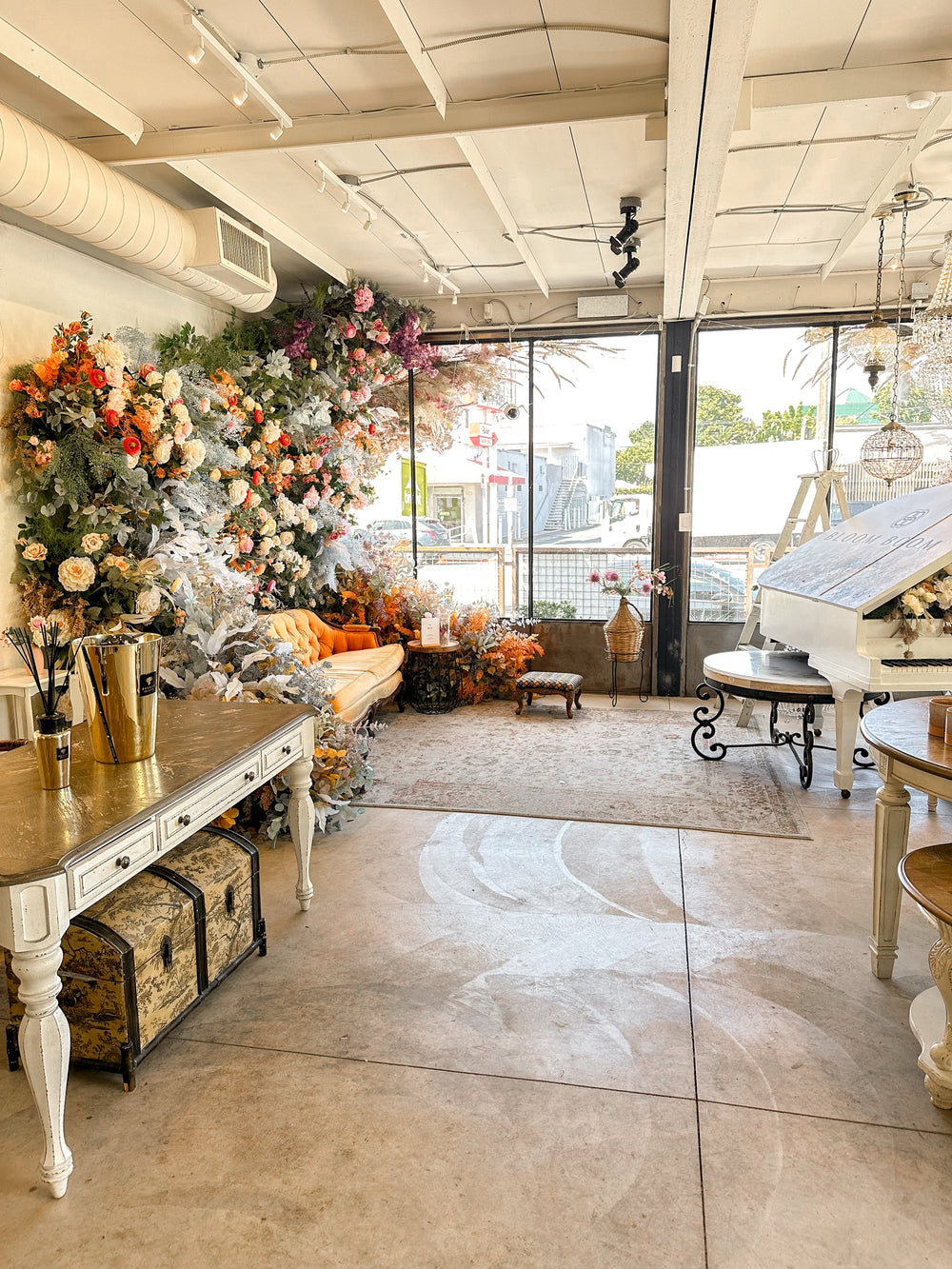 Bloom Boom event space interior with an autumn floral installation, tufted sofa and open patio doors