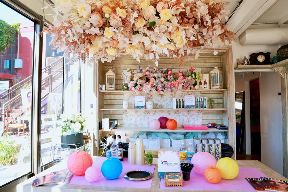 Bar and beauty stations styled with paper lanterns beneath the dried floral ceiling canopy