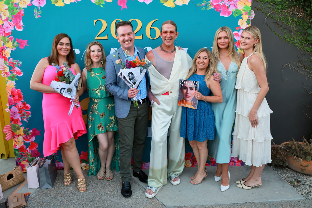 Award winners with bouquets and magazines posing at the floral step-and-repeat backdrop