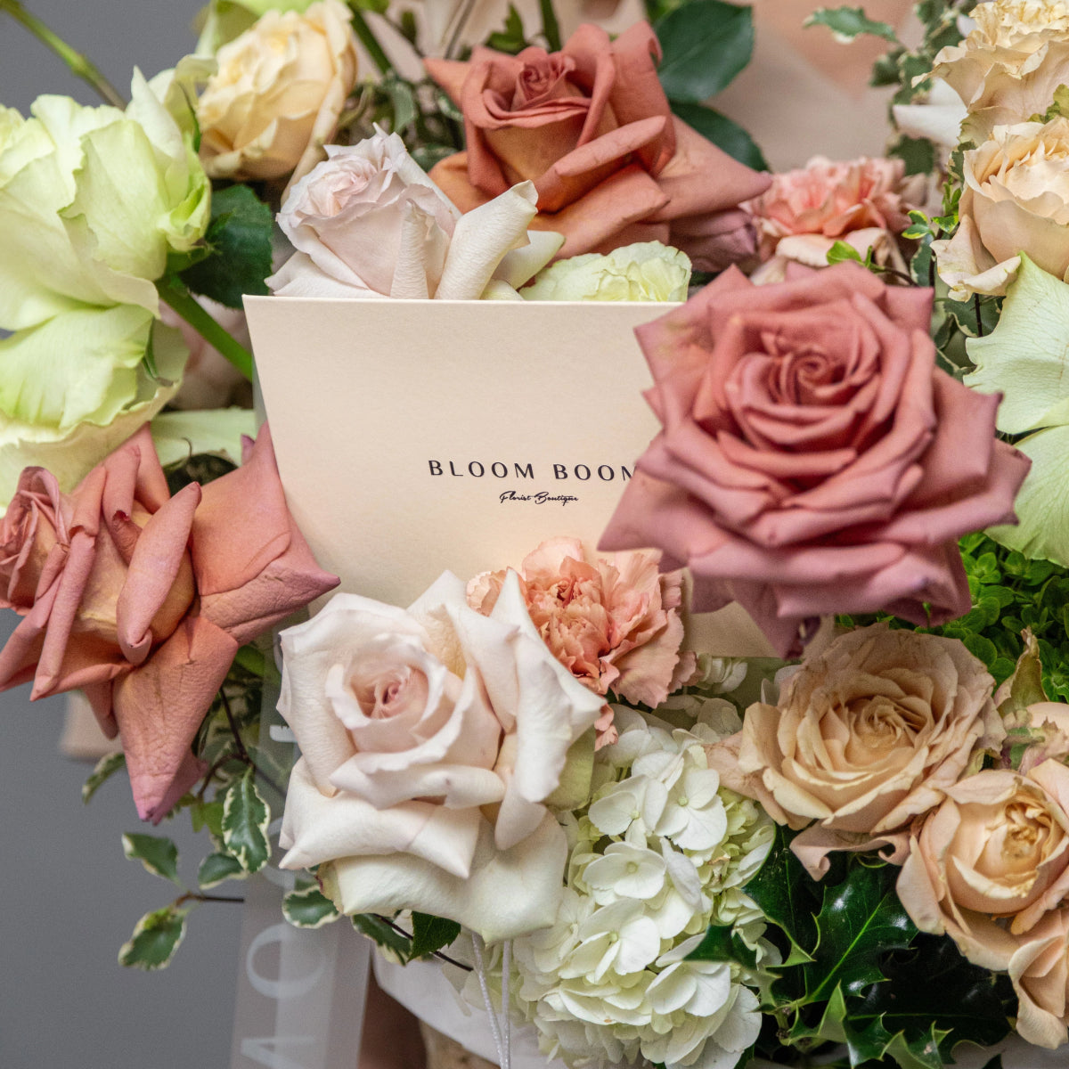 Bloom Boom luxury flower bouquet with dusty rose, cream, and white roses, hydrangeas, and carnations with brand card