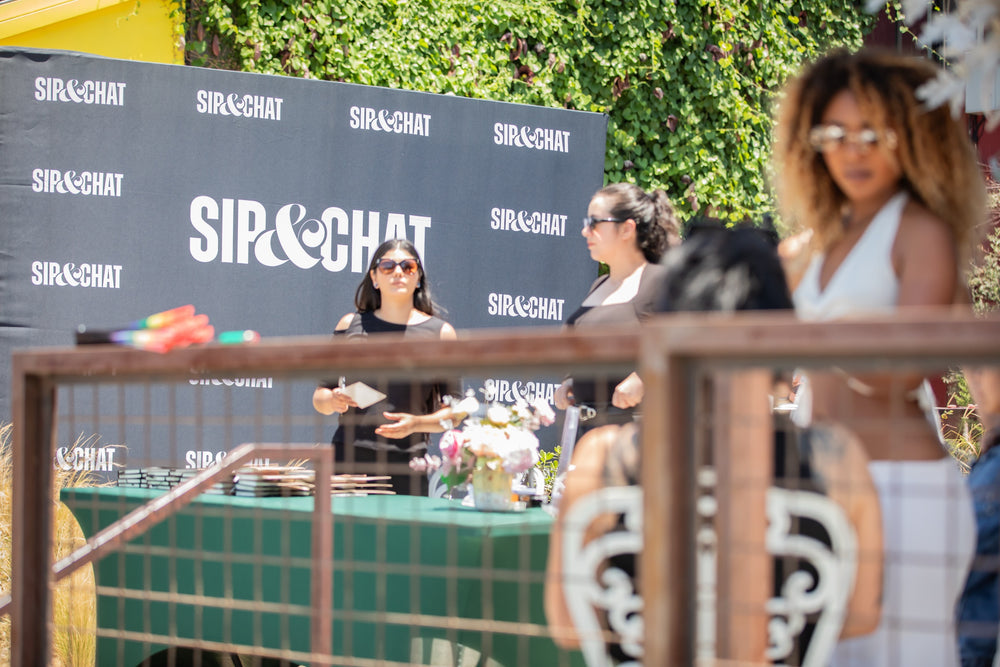 Sip & Chat branded step-and-repeat backdrop set up on the outdoor patio