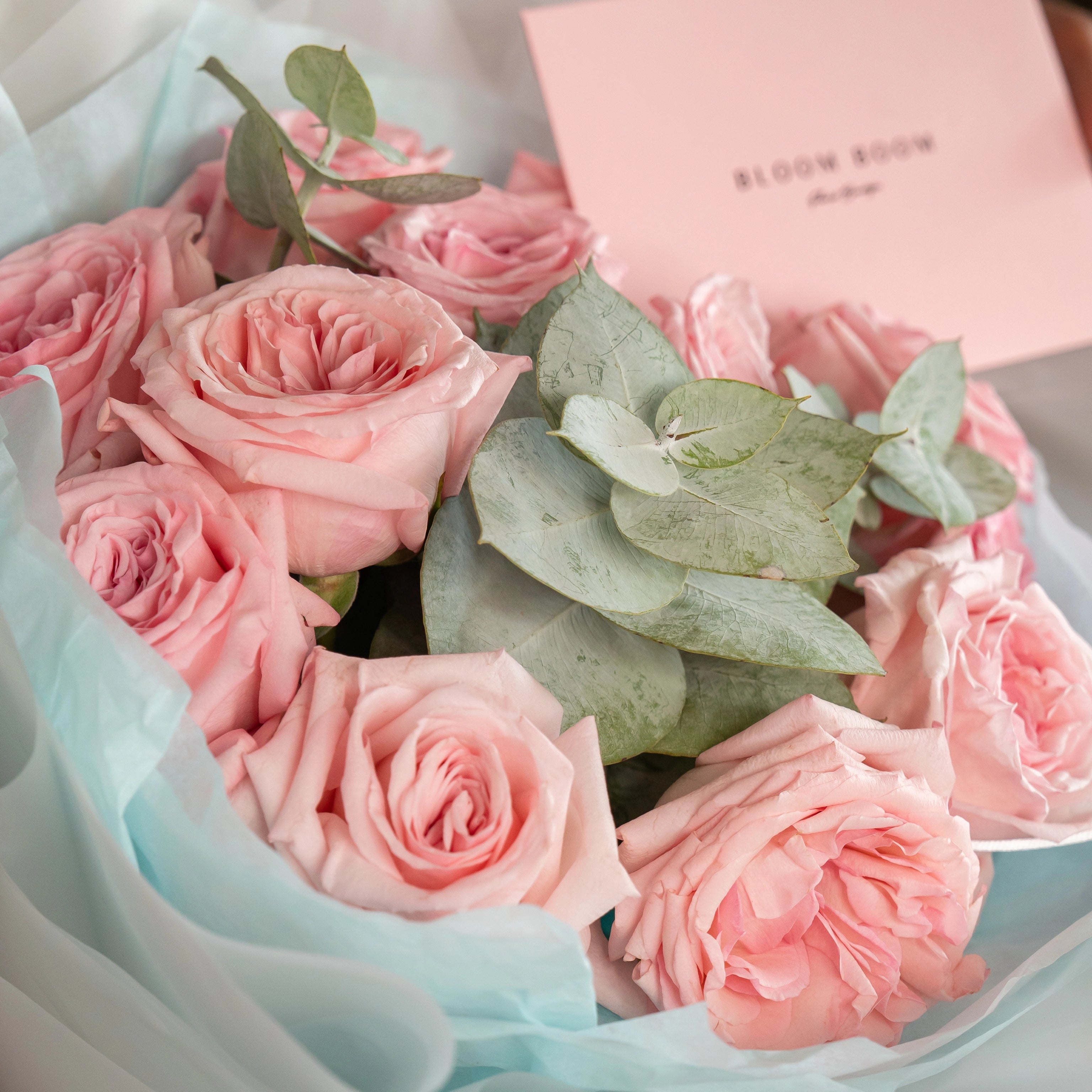 Blush pink rose bouquet with eucalyptus leaves wrapped in light blue paper - premium flower delivery Los Angeles