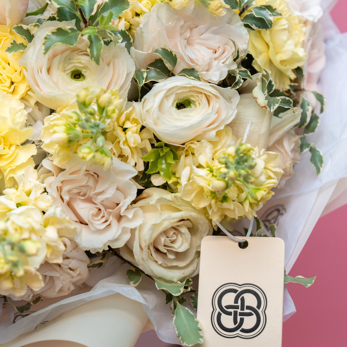 Cream and yellow wedding bouquet with roses, ranunculus and chrysanthemums tied with white silk ribbon