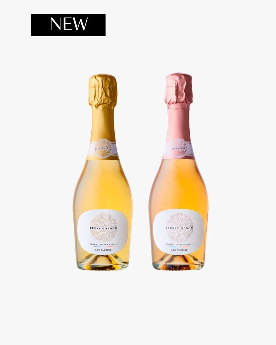 Two French Bloom organic non-alcoholic sparkling wine bottles with gold and pink foil tops, white oval labels