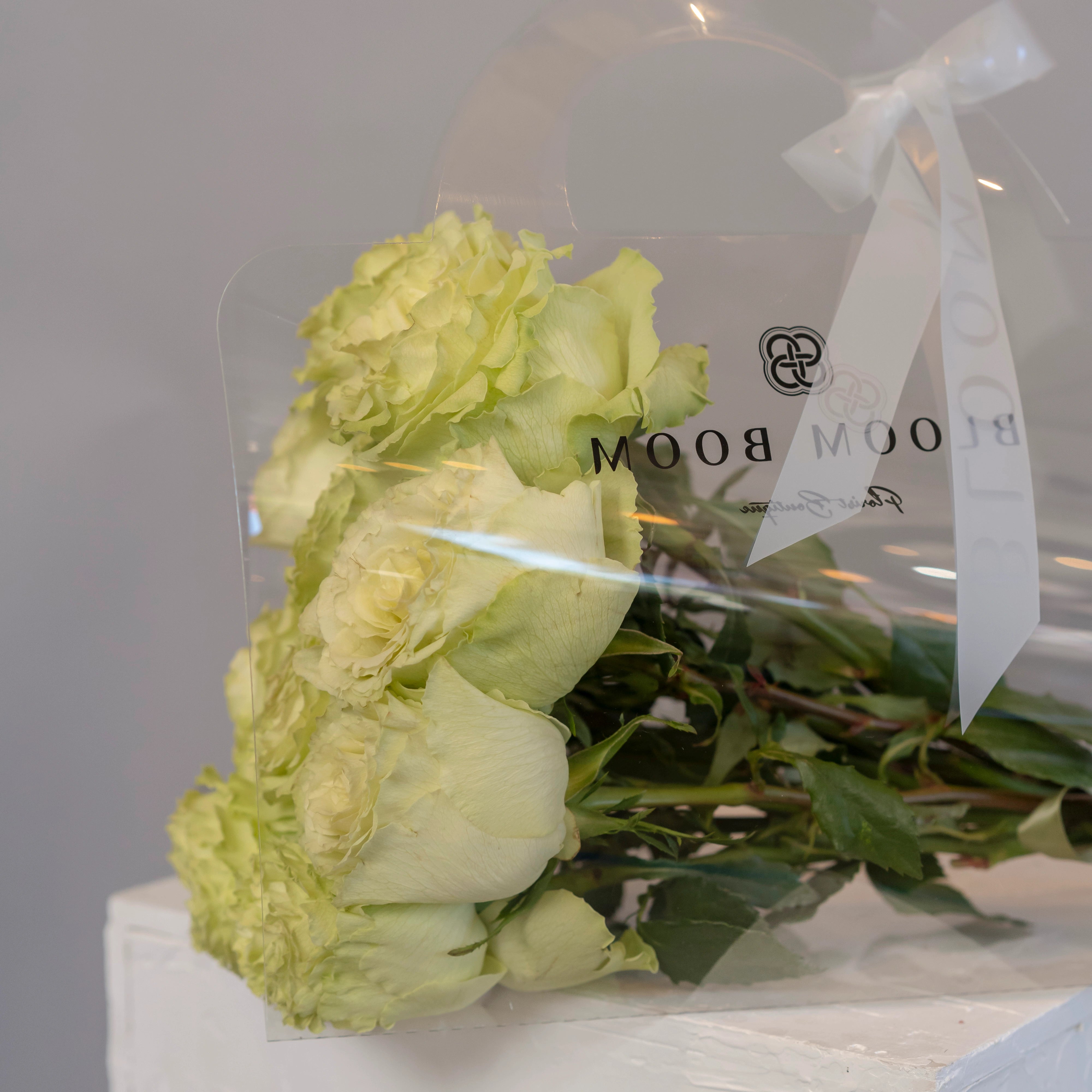 Lime green rose bouquet wrapped in cellophane with white ribbon from Bloom Boom Flowers Los Angeles florist
