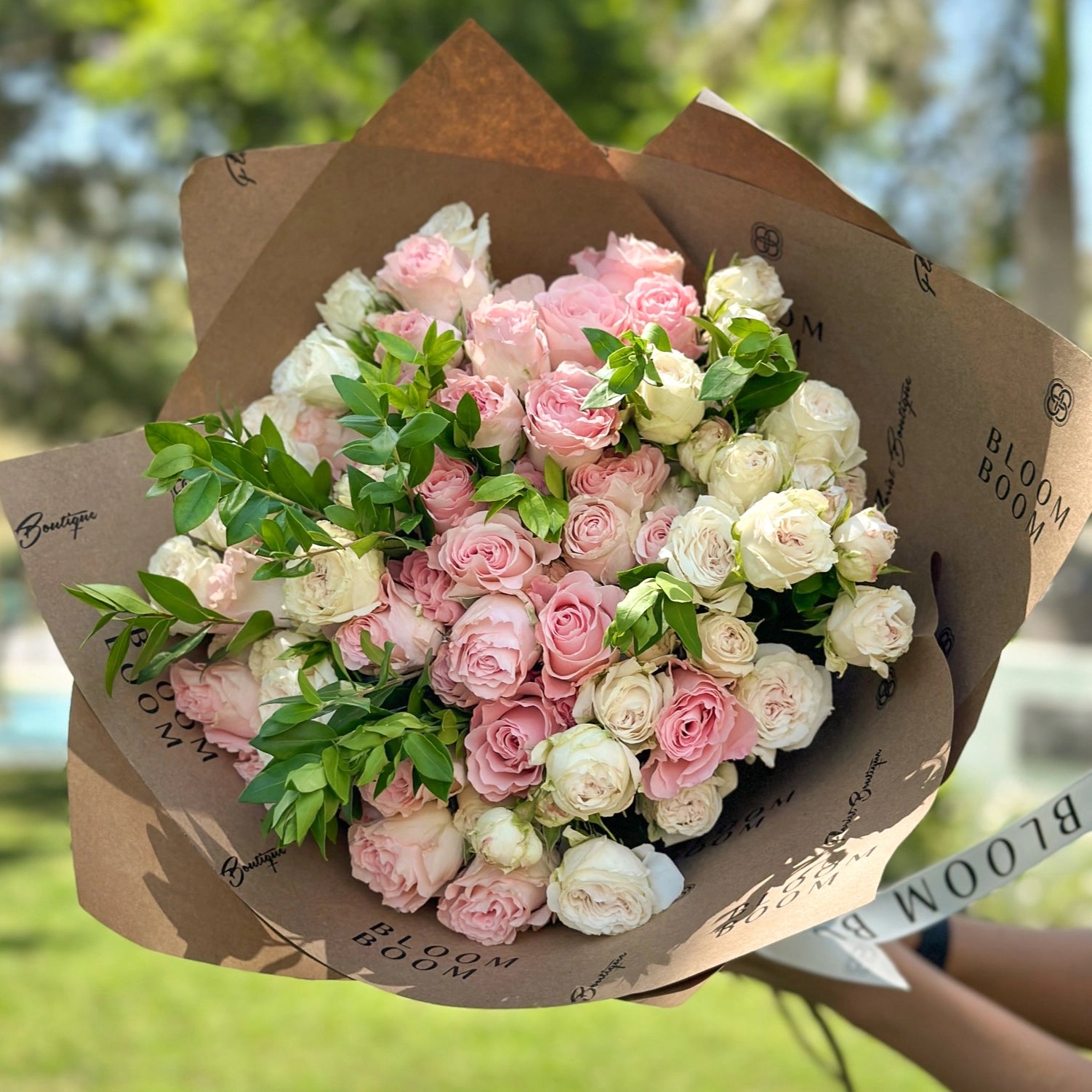 Pink and cream rose bouquet wrapped in branded kraft paper from Bloom Boom Flowers Los Angeles florist
