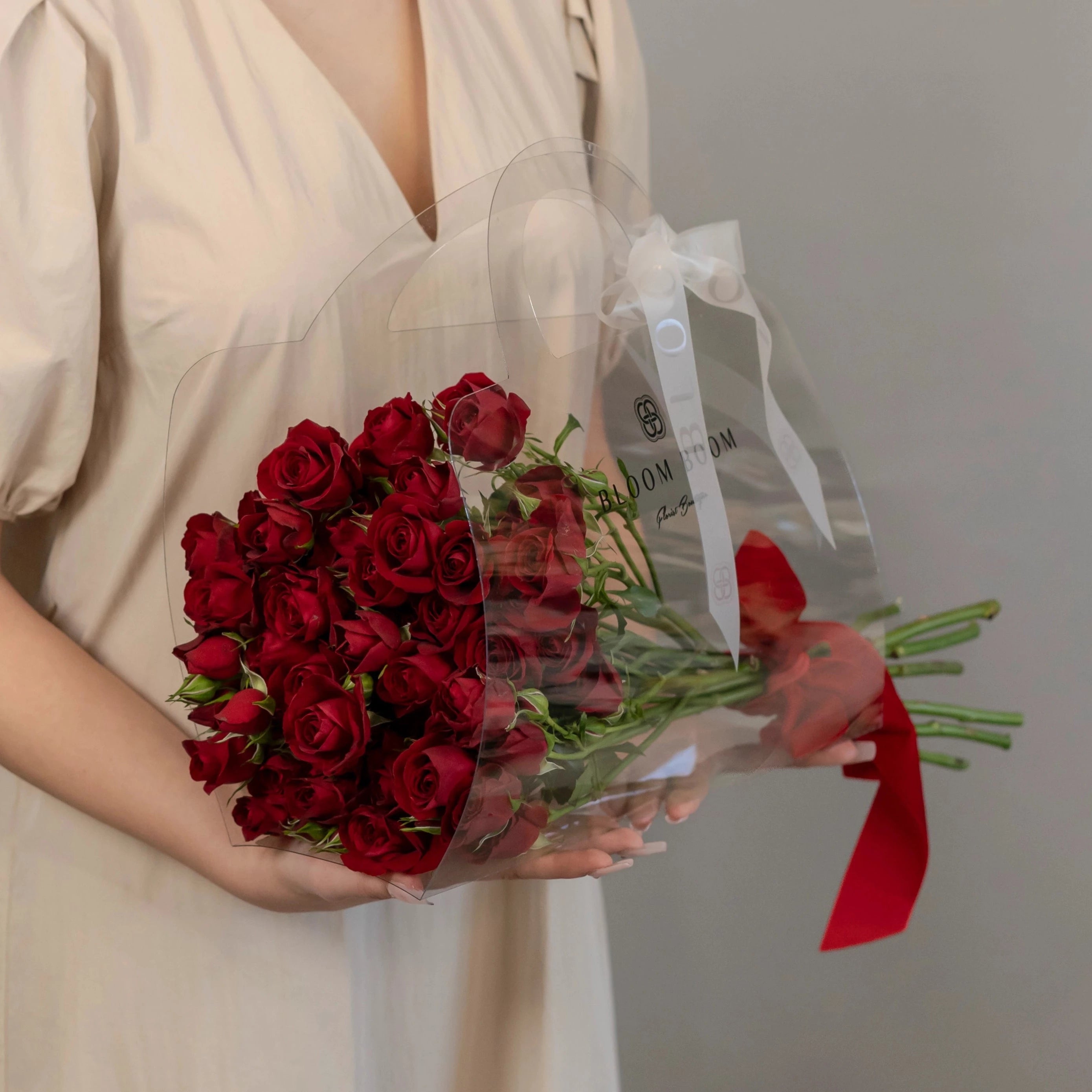 Deep red rose bouquet wrapped in clear cellophane with white ribbon, perfect for romantic occasions in Los Angeles