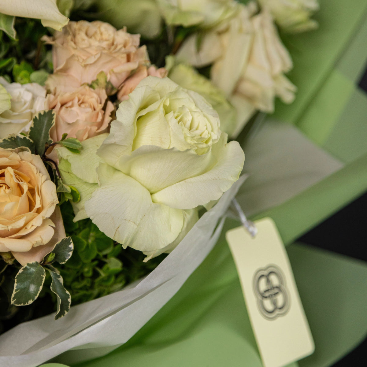 Cream and peach roses with green hydrangea in white gift box with ribbon and heart tag